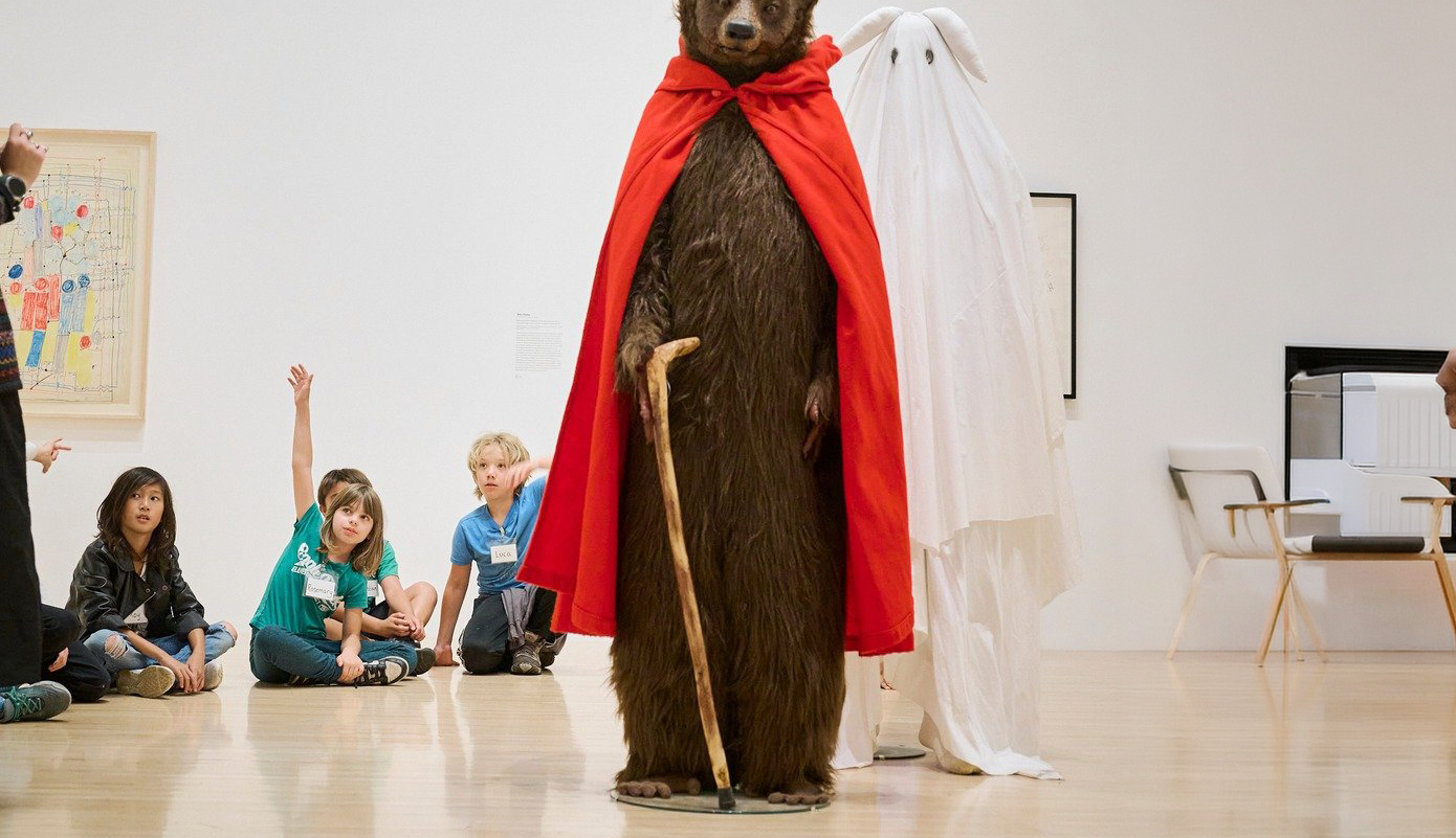 Photo of Students looking at a bear and rabbit statue.